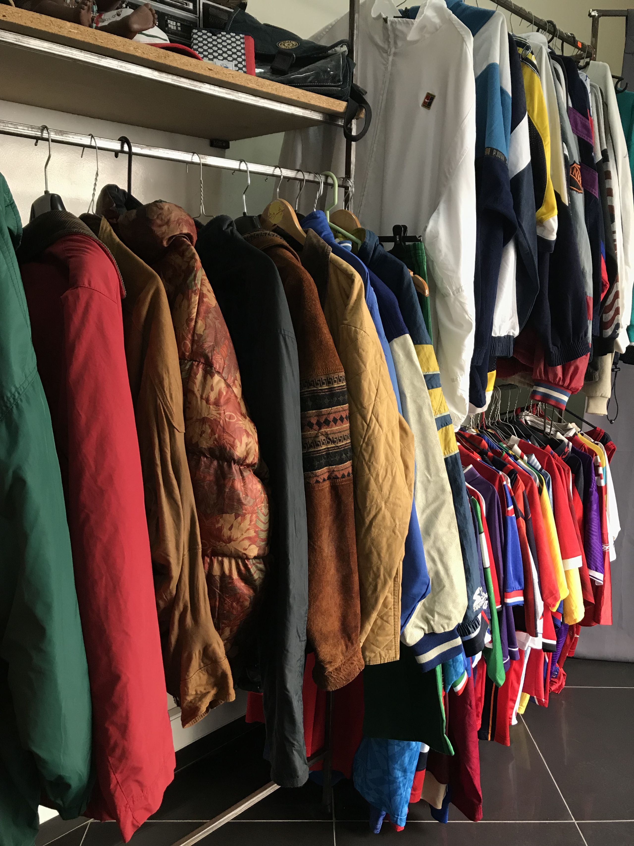 More colourful jackets and sports jerseys hung on clothes racks.