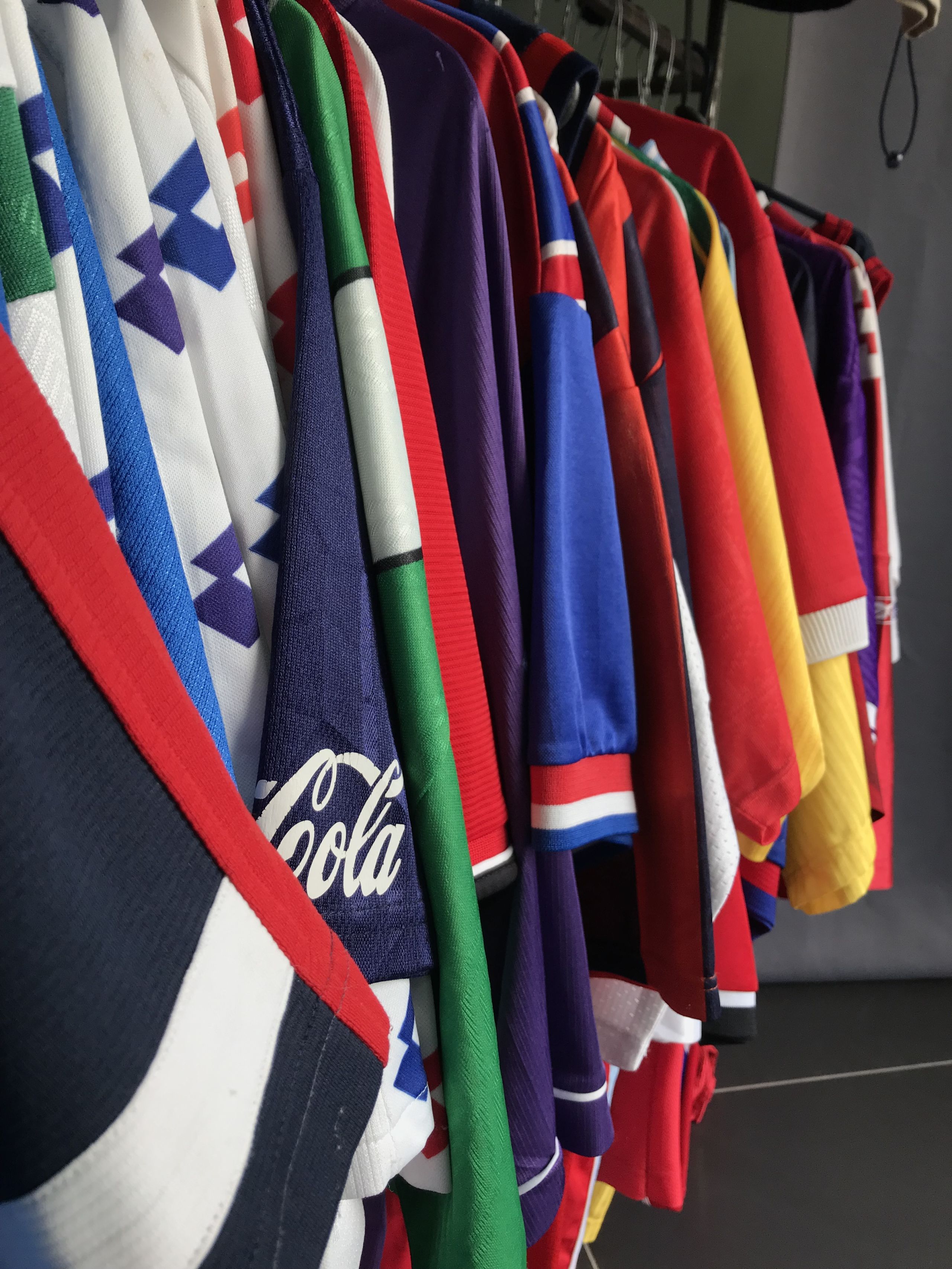 A colourful assortment of jackets and coats hanging up on a clothes rack.